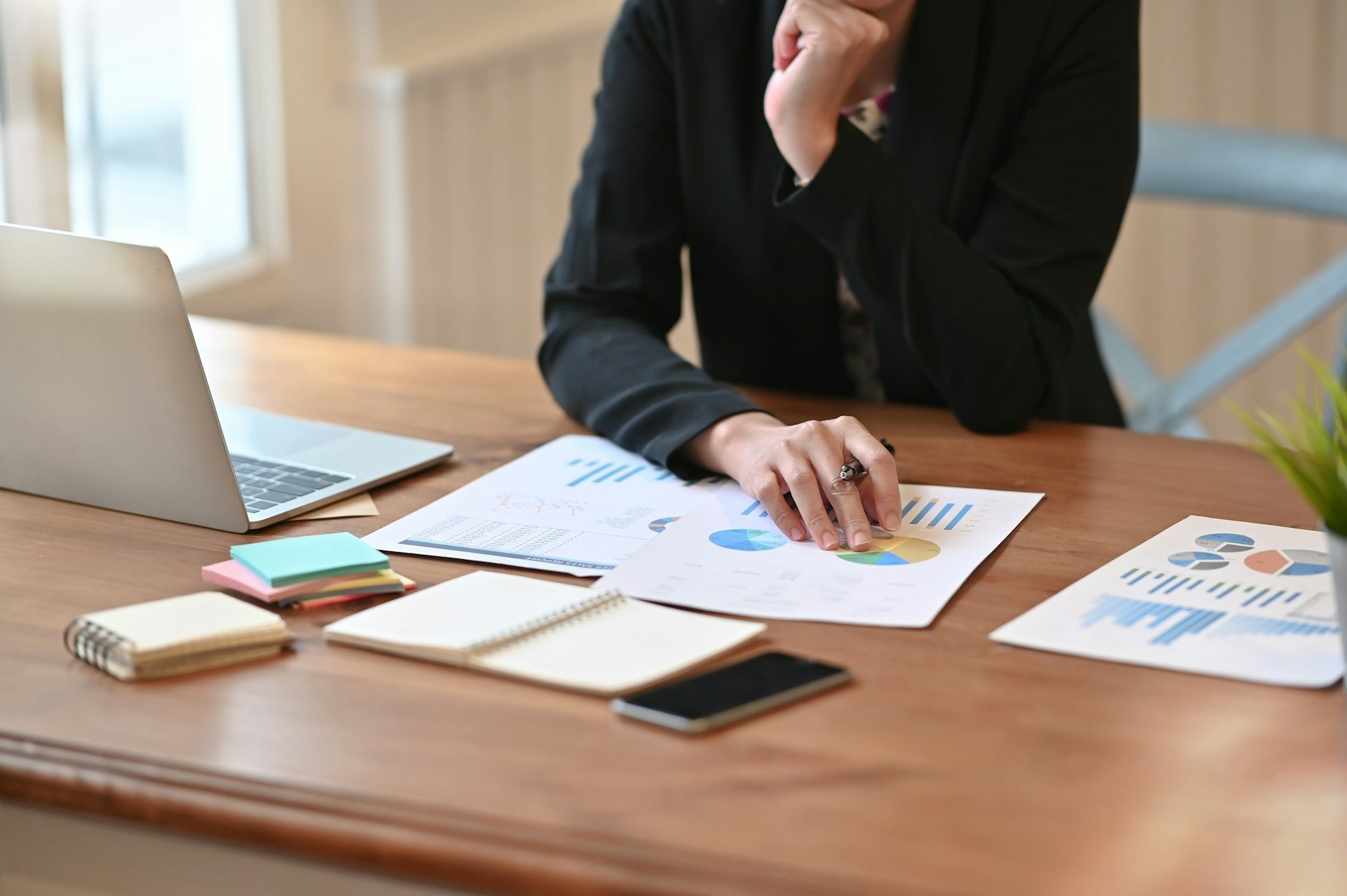 Professional reviewing reports and data charts at an office desk