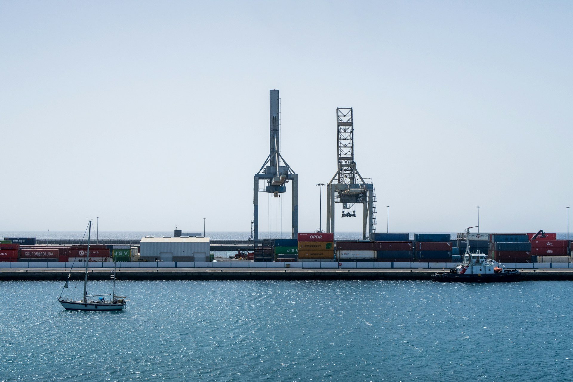 Puerto industrial con contenedores y grúas de carga junto al mar